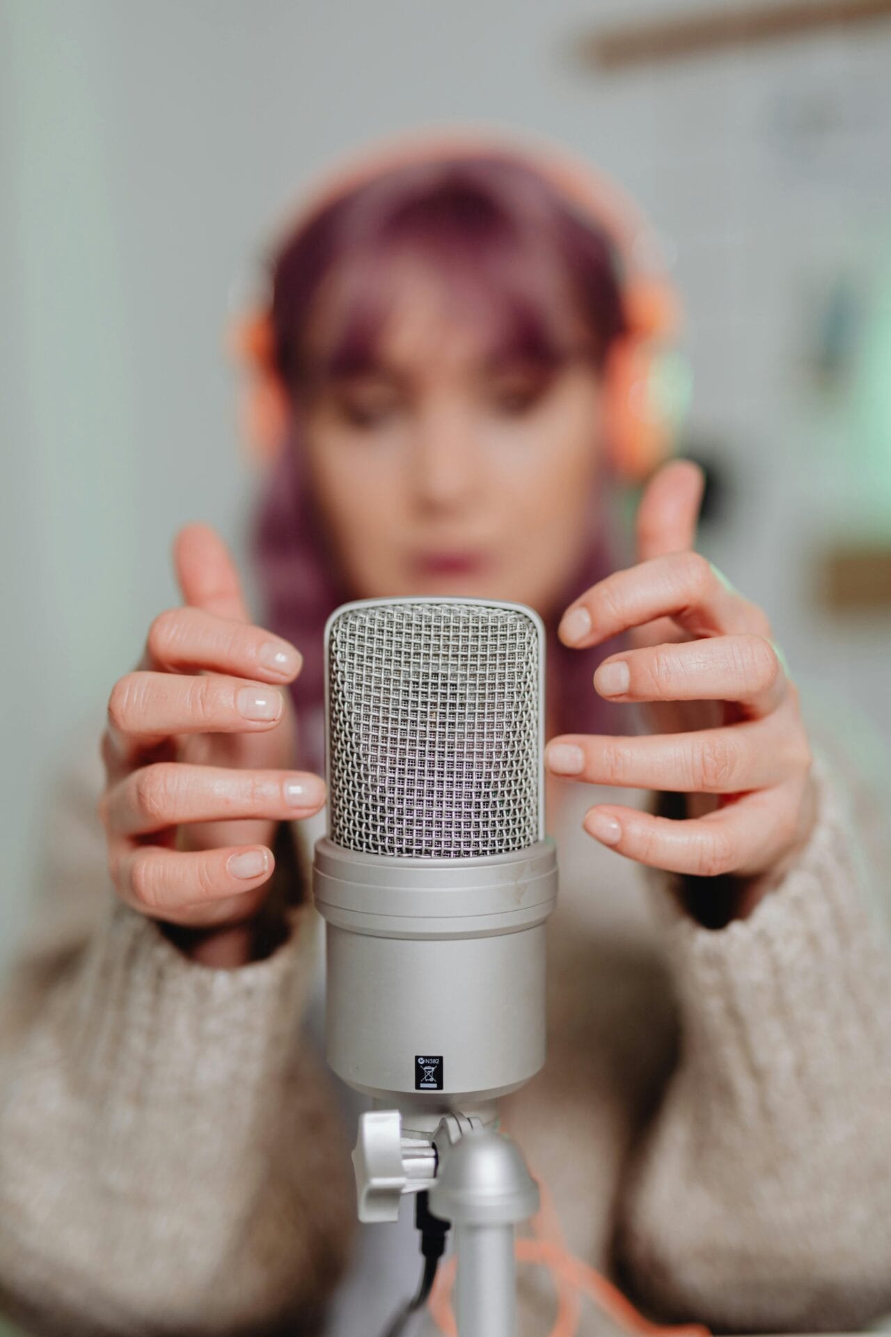 Close-up of a woman recording ASMR with a microphone indoors. Agent Podcast Clip Agent, Podcast Clip Automation.